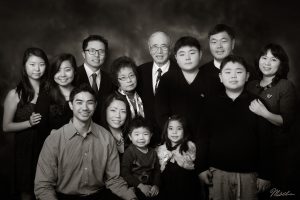 Black and white portrait of a large multi-generational East Asian family with thirteen members.